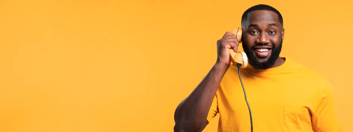 An African American man holding a telephone handset to his ear